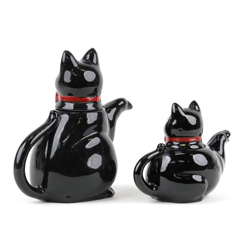 1233 - Two similar graduated teapots in the form of cats 19cm high.