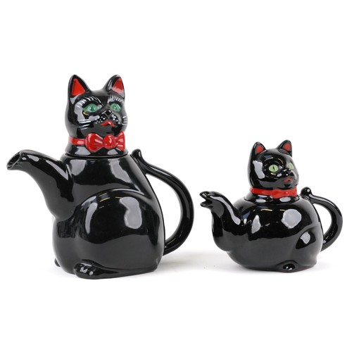 1233 - Two similar graduated teapots in the form of cats 19cm high.