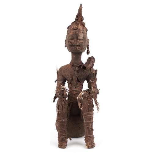 478 - An African tribal carved softwood seated figure, possibly Benin, circa 1900, bound with string and f... 