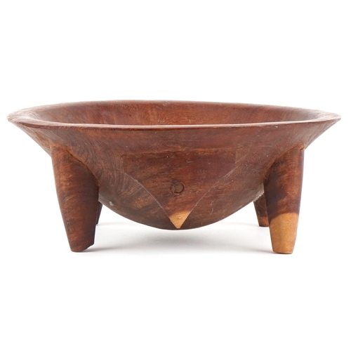 473 - An African carved hardwood mixing bowl, 20th century, raised on four tapering legs, 15cm high x 38cm... 