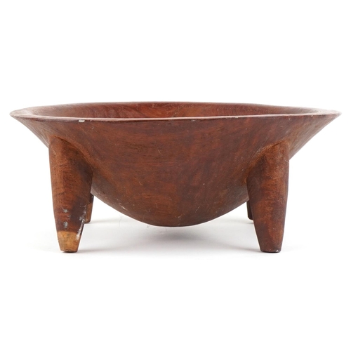 473 - An African carved hardwood mixing bowl, 20th century, raised on four tapering legs, 15cm high x 38cm... 