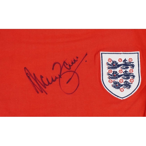 1410 - A replica 1966 red England World Cup long sleeved football jersey signed by Alan Ball, M.