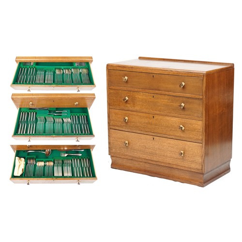 An Art Deco oak canteen chest of four long drawers with Bakelite handles containing a Rogers plated canteen of cutlery, 77cm high x 81cm wide.