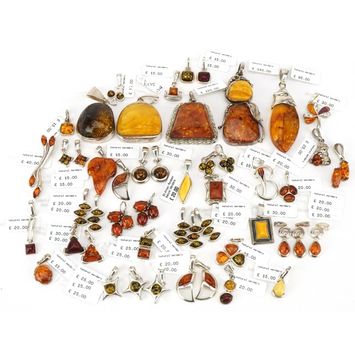 3726 - A large collection of silver mounted amber pendants, predominantly with Natural Wonders labels, the ... 