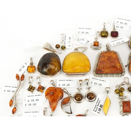 3726 - A large collection of silver mounted amber pendants, predominantly with Natural Wonders labels, the ... 