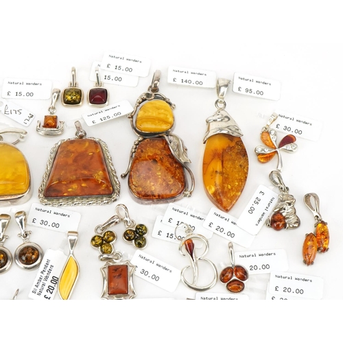 3726 - A large collection of silver mounted amber pendants, predominantly with Natural Wonders labels, the ... 