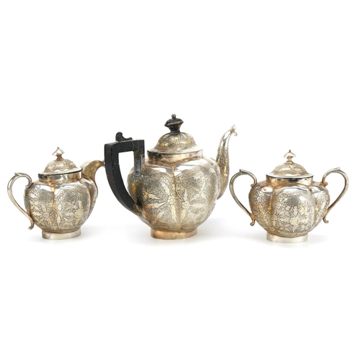 558 - An Indian white metal tea service profusely engraved with flowers and foliage, the teapot 20cm in le... 