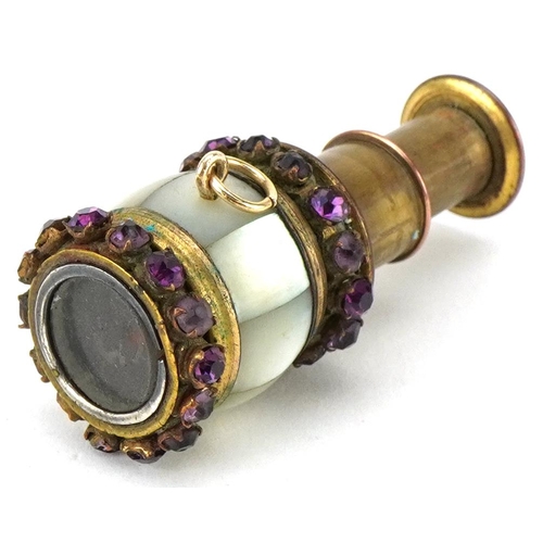 A miniature brass and mother of pearl two draw monocular set with purple stones, 4.5cm in length extended.