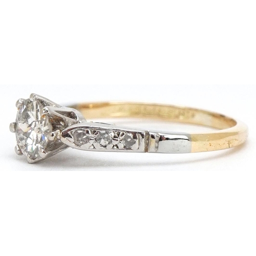 3024 - An 18ct gold and platinum diamond solitaire ring with diamond set shoulders, the solitaire diamond a... 