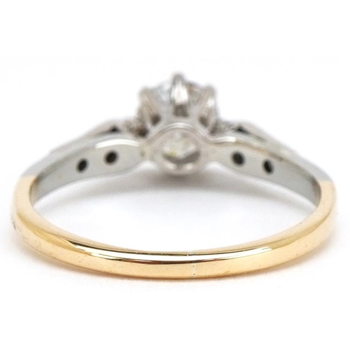 3024 - An 18ct gold and platinum diamond solitaire ring with diamond set shoulders, the solitaire diamond a... 