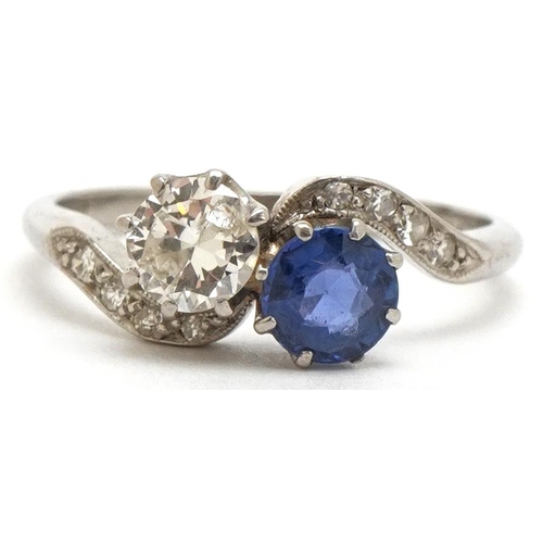 A platinum diamond and sapphire crossover ring, the diamond solitaire approximately 0.35 carat, size K, 2.9g.