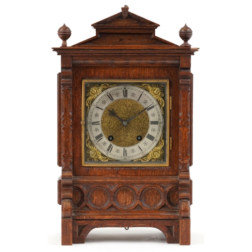 199 - A Victorian Gothic Revival oak mantle clock, the silvered dial with black Roman numerals, striking o... 