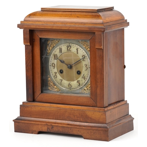 201 - A Victorian walnut cased mantle clock, with silvered dial, striking on a gong, raised on plinth brac... 