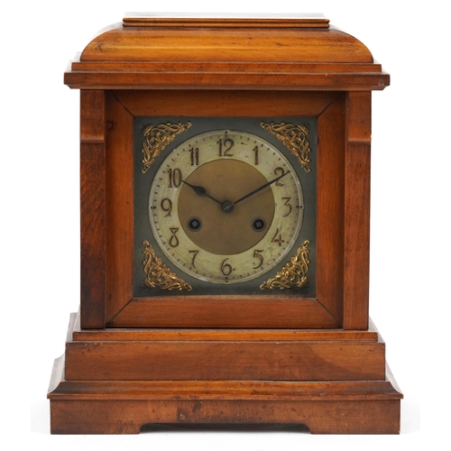 201 - A Victorian walnut cased mantle clock, with silvered dial, striking on a gong, raised on plinth brac... 