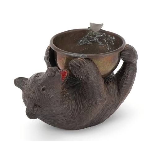 66 - An early 20th century Swiss Black Forest carved bear ashtray, 15cm in length.