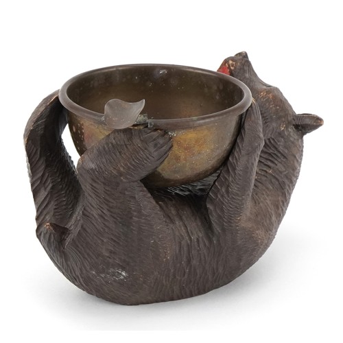 66 - An early 20th century Swiss Black Forest carved bear ashtray, 15cm in length.