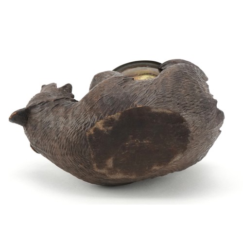 66 - An early 20th century Swiss Black Forest carved bear ashtray, 15cm in length.