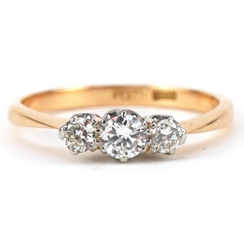 3008 - An 18ct gold and platinum diamond three stone ring, the central diamond approximately 0.15 carat, si... 