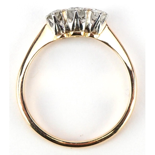 3008 - An 18ct gold and platinum diamond three stone ring, the central diamond approximately 0.15 carat, si... 