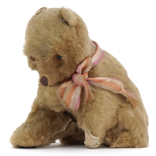 1088 - A small early 20th century mohair seated stuffed bear with glass eyes and stitched nose, 8cm high.