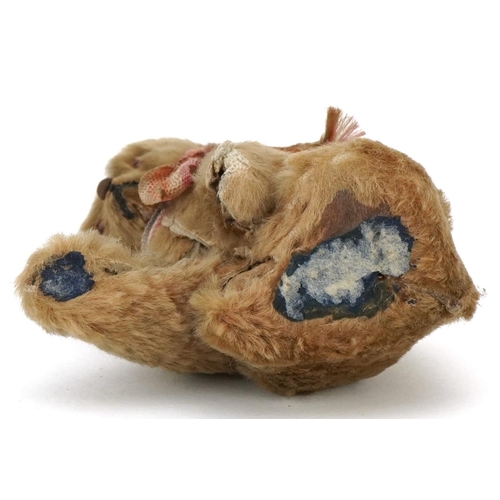 1088 - A small early 20th century mohair seated stuffed bear with glass eyes and stitched nose, 8cm high.