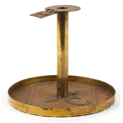 105 - An Arts & Craft brass candlestick with applied copper stylized motif, 18cm high.