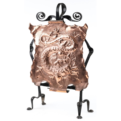 167 - A late 19th century Arts & Crafts wrought iron and embossed copper fire screen decorated with a drag... 