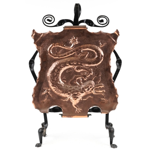 167 - A late 19th century Arts & Crafts wrought iron and embossed copper fire screen decorated with a drag... 