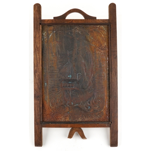 458 - An Edwardian Arts & Crafts oak and embossed tin fire screen decorated with a boat, 72cm x 42cm.