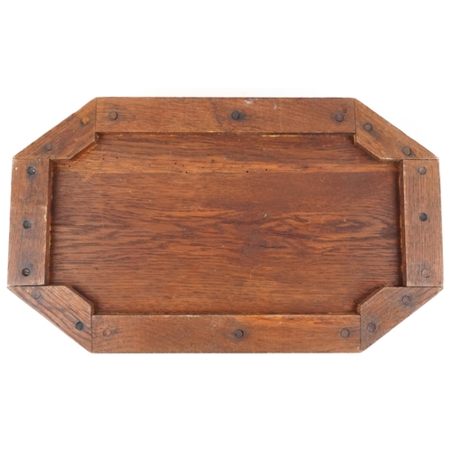 398 - An Arts & Crafts oak canted rectangular tray, the top carved with a bird, fitted with two bobbin tur... 