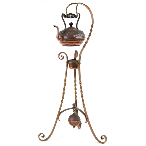 A late 19th century Arts & Crafts copper and brass kettle and stand, the kettle with a wrought iron handle, raised on three scroll supports, 78cm high.