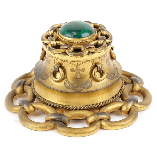 104 - An Arts & Crafts brass inkwell, the hinged lid set with a cabochon malachite panel and ring turned h... 