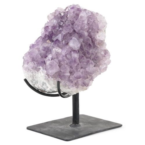 1599 - A large amethyst geode on a wrought iron display stand, overall 21cm high.