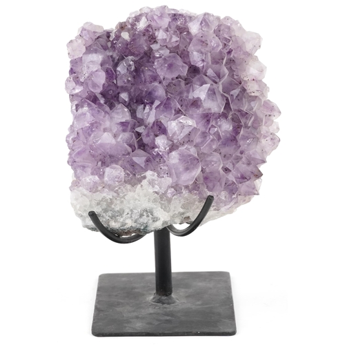 1599 - A large amethyst geode on a wrought iron display stand, overall 21cm high.