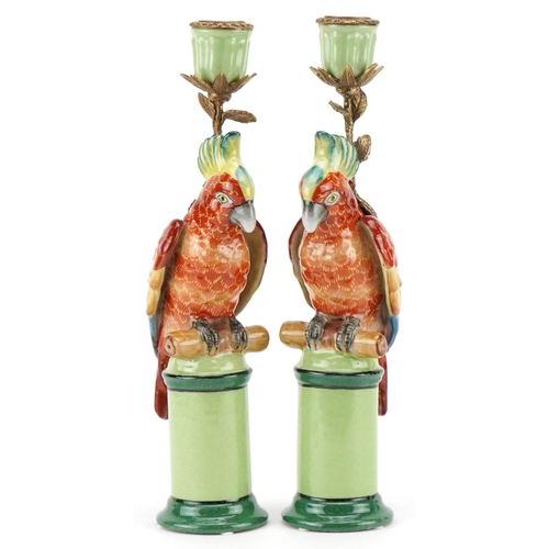 1586 - A pair of continental porcelain and brass candlesticks in the form of parrots, 28cm high.