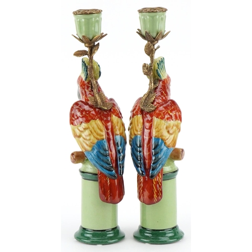 1586 - A pair of continental porcelain and brass candlesticks in the form of parrots, 28cm high.