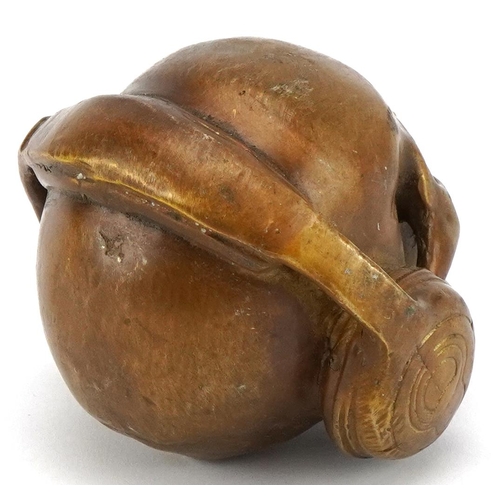 1620 - A patinated bronze study of a human skull wearing headphones, 7.5cm high.