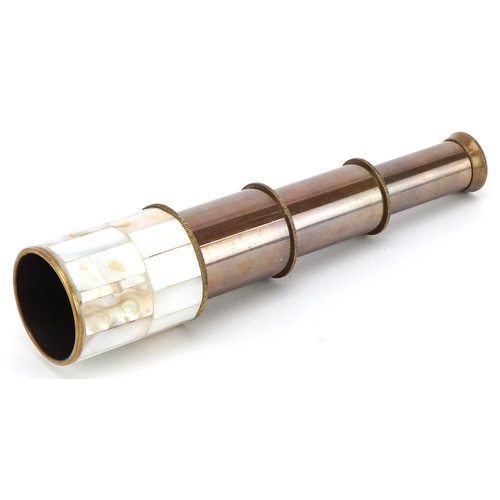 1610 - A brass and mother of pearl three draw pocket telescope, 18cm in length extended.