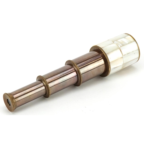 1610 - A brass and mother of pearl three draw pocket telescope, 18cm in length extended.