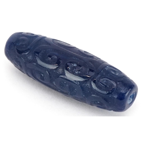 391 - An Islamic carved blue stone bead, 4cm in length.