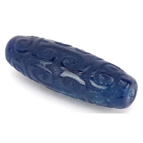 391 - An Islamic carved blue stone bead, 4cm in length.