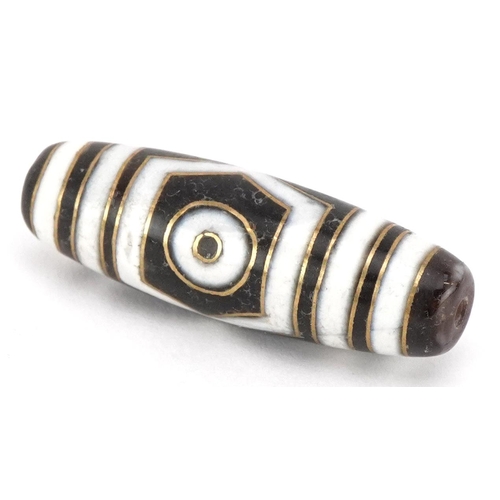 390 - An Islamic agate bead with yellow metal inlay, 3.8cm in length, 8.8g.