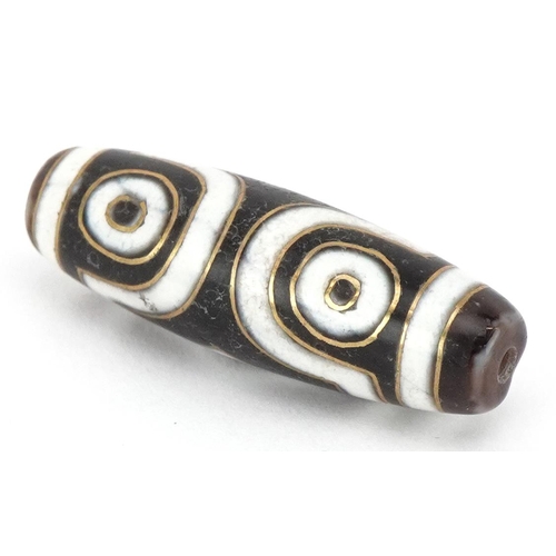 390 - An Islamic agate bead with yellow metal inlay, 3.8cm in length, 8.8g.