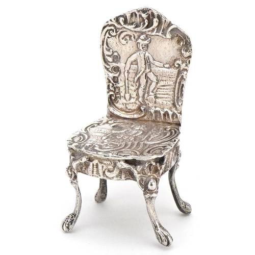 597 - A Victorian silver doll's house chair embossed with a formally dressed lady and gentleman, JW maker'... 