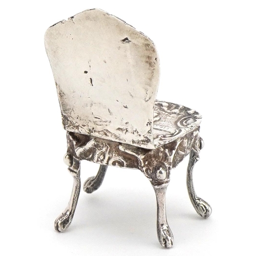 597 - A Victorian silver doll's house chair embossed with a formally dressed lady and gentleman, JW maker'... 