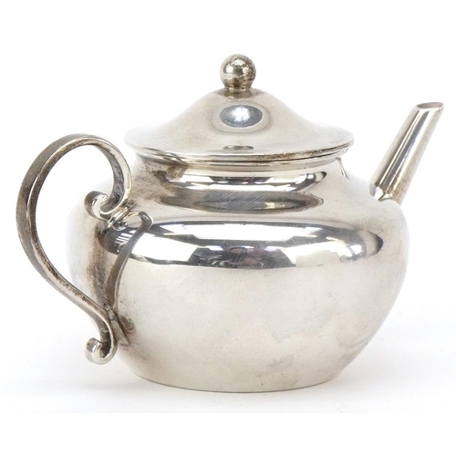 568 - Willian Comyns, a George V silver doll's house teapot, 9cm in length, London 1914, 69.5g.