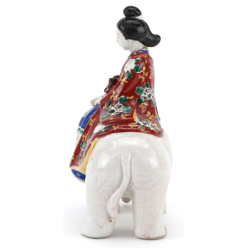 374 - A Japanese porcelain model of a Bijin riding a white elephant, Meiji period, with hand painted decor... 