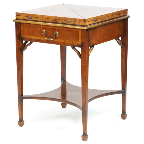 2134 - A late 20th century walnut envelope card table with cross banded decoration, the rotating top raised... 