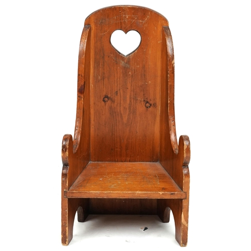 2132 - An early 20th century pine child's chair, the back pierced with a heart, raised on bracket feet, 61c... 