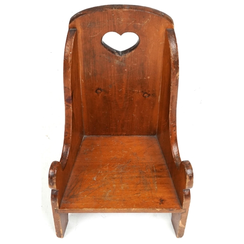 2132 - An early 20th century pine child's chair, the back pierced with a heart, raised on bracket feet, 61c... 